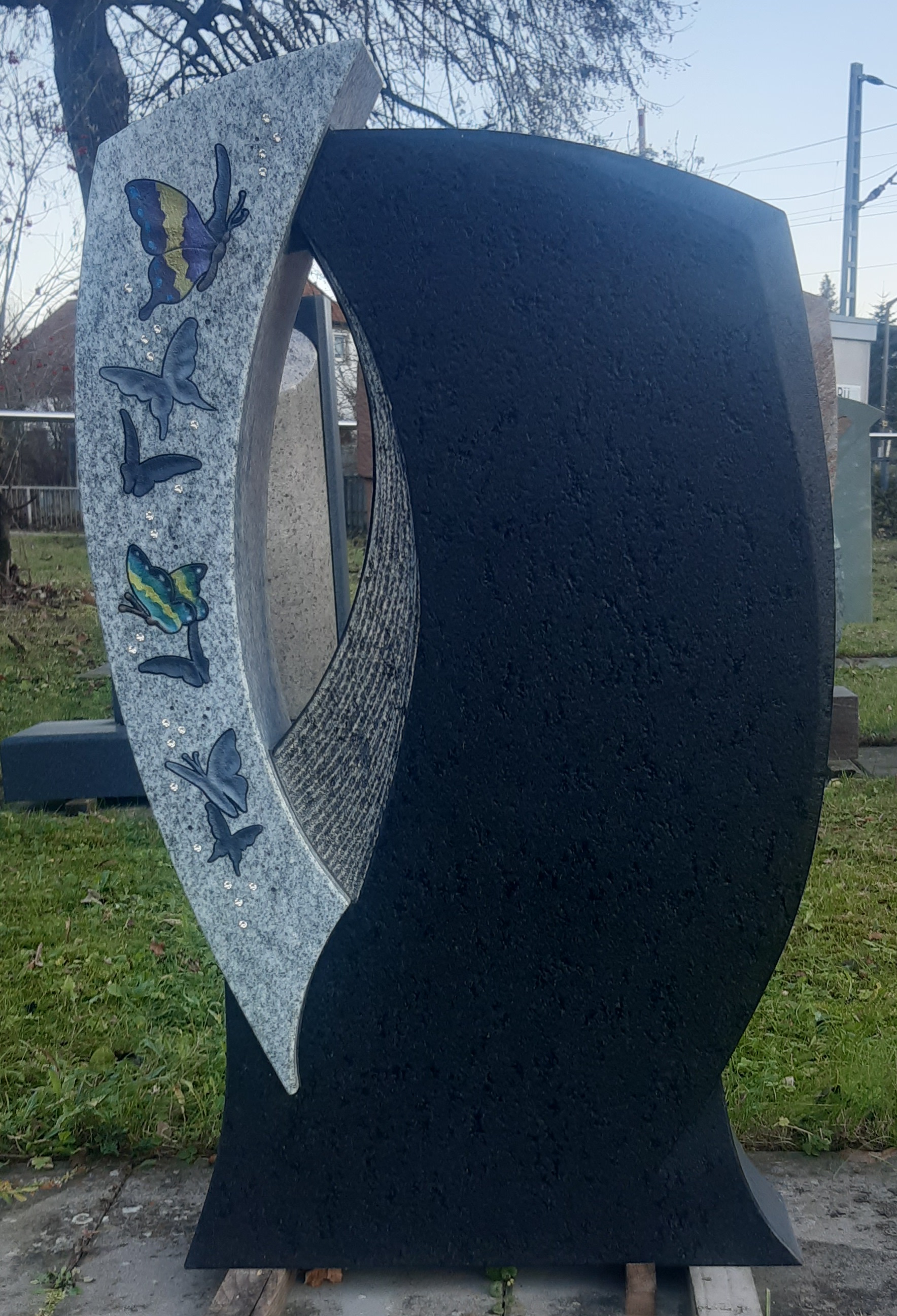 Geteilter Grabstein mit Schmetterlingsmotiv