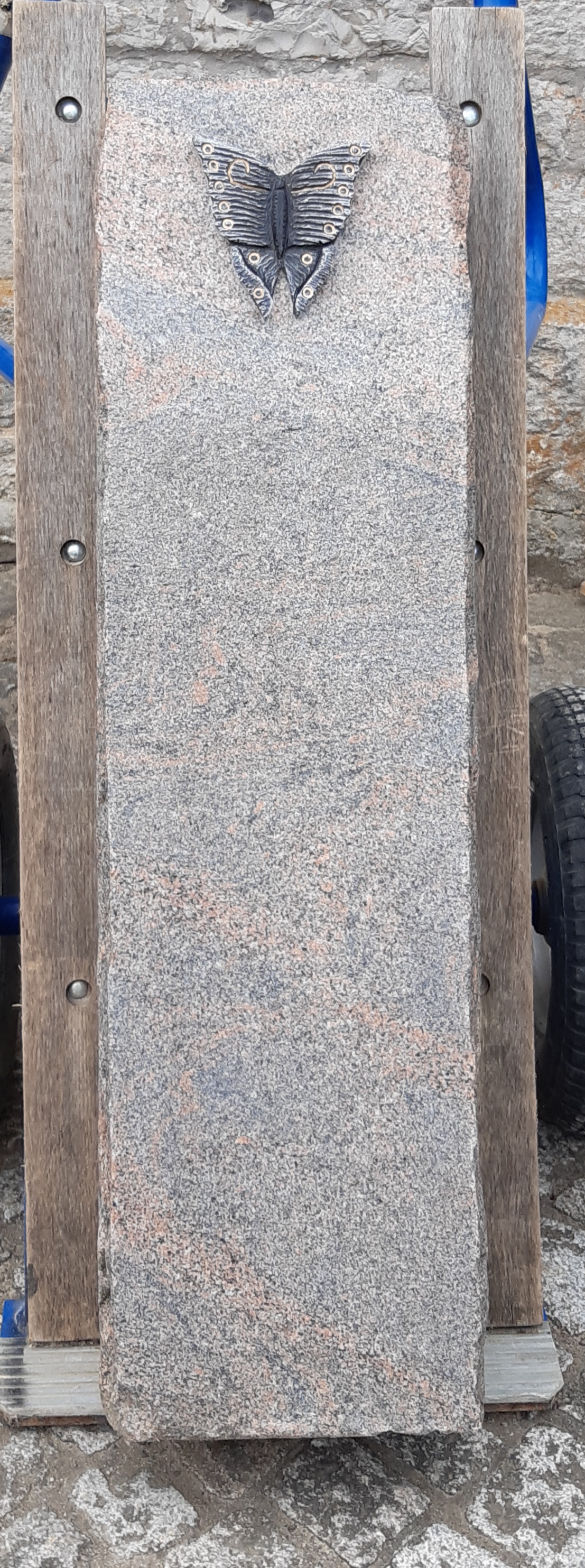 Grauer Grabstein mit Schmetterlingsrelief