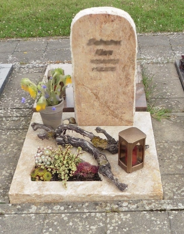 Heller Grabstein mit Trockenarrangement
